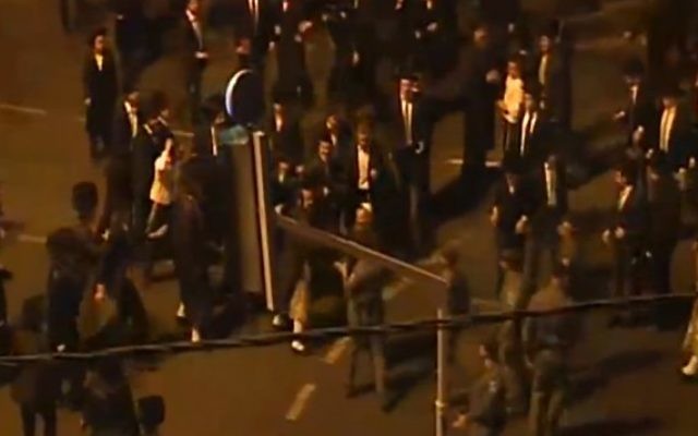 Des hommes ultra-orthodoxes affrontent la police pendant une manifestation contre l'ouverture pendant Shabbat du cinéma Yes Planet, à Jérusalem, le 14 août 2015. (Crédit : capture d'écran Deuxième chaîne)