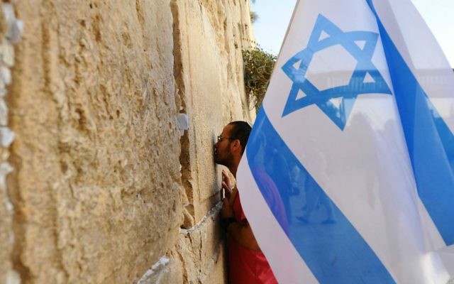 Un homme tient un drapeau israélien au cours d'une marche de soutien à la ville de Jérusalem au mur Occidental le 22 octobre, 2015, après une vague d'attaques terroristes (Crédit photo: Mendy Hechtman / Flash90) Un homme tient un drapeau israélien au cours d'une marche de soutien à la ville de Jérusalem au mur Occidental le 22 octobre, 2015, après une vague d'attaques terroristes (Crédit photo: Mendy Hechtman / Flash90)