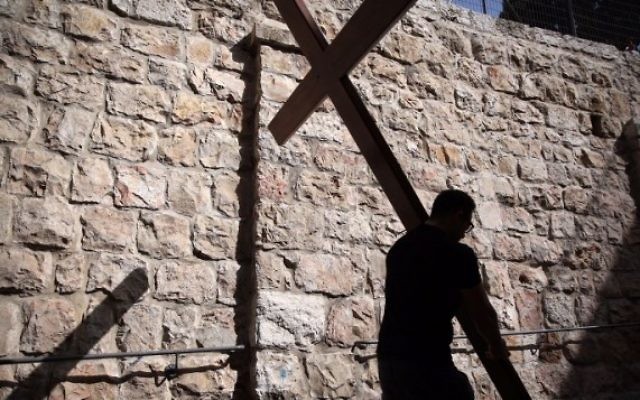 Un pèlerin catholique porte une croix de bois le long de la Via Dolorosa (chemin de la souffrance) dans la Vieille Ville de Jérusalem pendant la procession du Vendredi, le 25 mars 2016. (Crédit : Gali Tibbon / AFP)