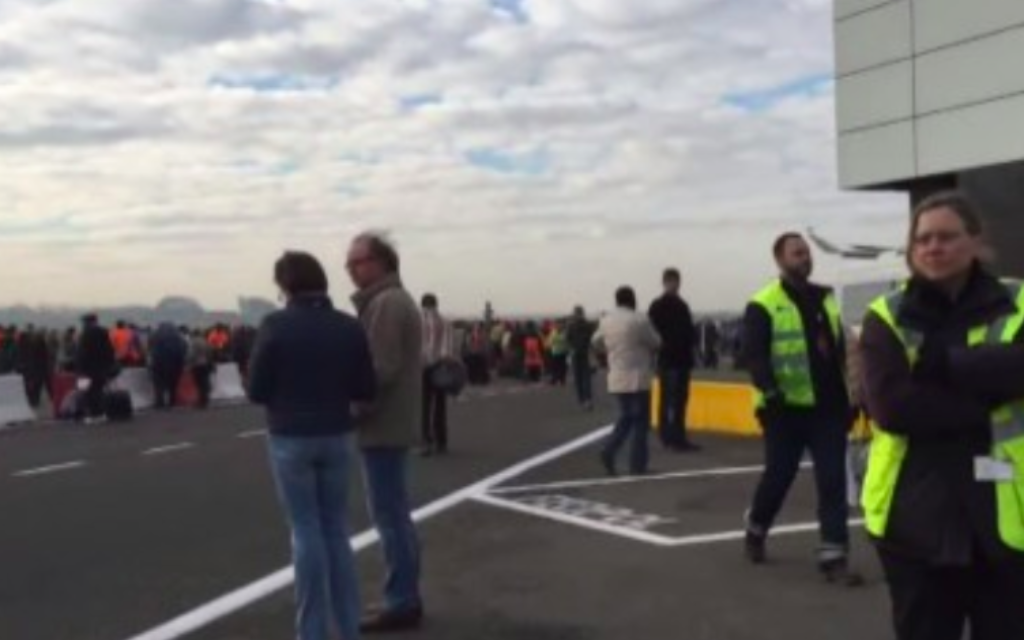 Les passagers se tiennent sur le tarmac après qu'ils ont été évacués de Bruxelles suite à deux explosions le 22 mars 2016 (Crédit : capture d'écran YouTube) Les passagers se tiennent sur le tarmac après qu'ils ont été évacués de Bruxelles suite à deux explosions le 22 mars 2016 (Crédit : capture d'écran YouTube)