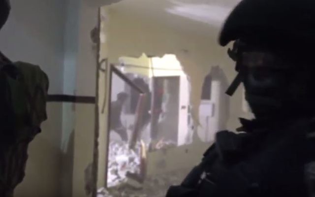 Des officiers de la police des frontières et des soldats ferment l'appartement d'un terroriste palestinien à Hébron, le 8 mars 2016. (Crédit : capture d'écran YouTube/Judah Ari Gross)