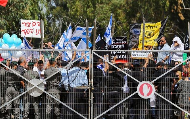 Les Israéliens manifestant devant un tribunal militaire pour soutenir un soldat qui a été accusé d'avoir tué un Palestinien blessé, le mardi 29 mars 2016 (Crédit : Flash90)