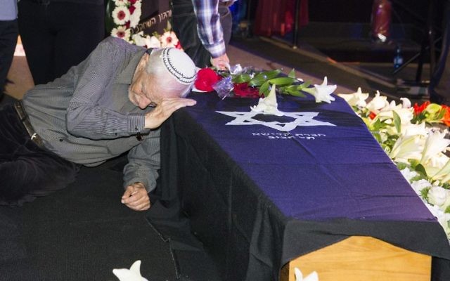 Le père de l'actrice Ronit Elkabetz penché sur le cercueil de sa fille pendant une cérémonie d'hommage à la cinémathèque de Tel Aviv avant ses funérailles, le 20 avril 2016. (Crédit : AFP PHOTO / JACK GUEZ)