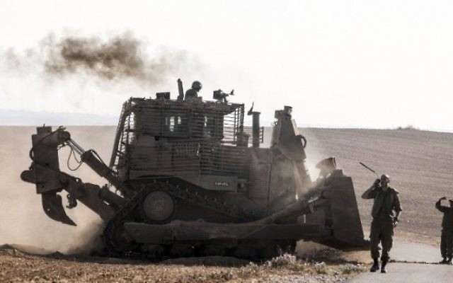 Un bulldozer israélien D9 le long de la frontière sud d'Israël avec la bande de Gaza, après des frappes aériennes israéliennes sur la bande de Gaza, le 10 juillet 2014 (Crédit : Jack Guez/AFP)