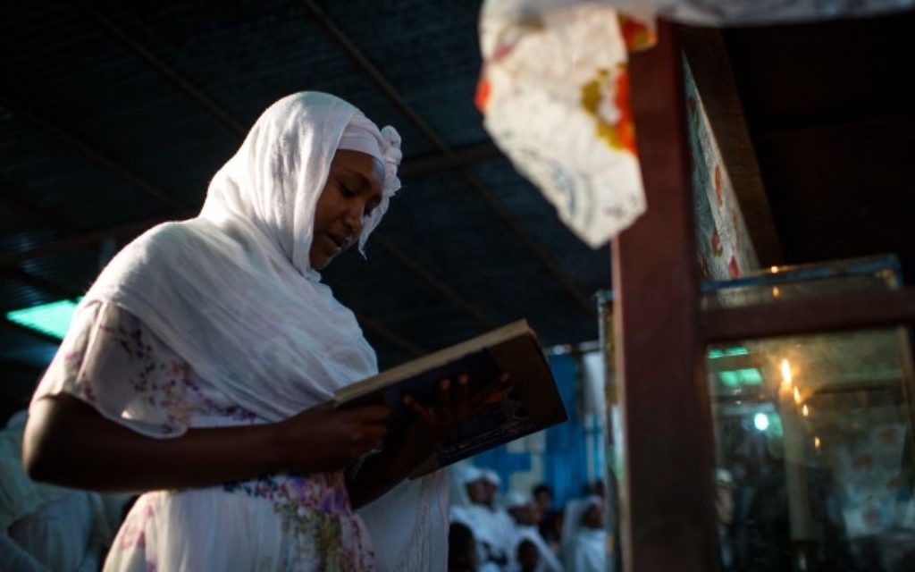 Une membre de la communauté juive éthiopienne Falash Mura allume les bougies de Shabbat avant les prières de Shabbat et de Pessah dans la synagogue de Gondar, en Ethiopie, le 22 avril 2016. (Crédit : Miriam Alster/FLASH90)