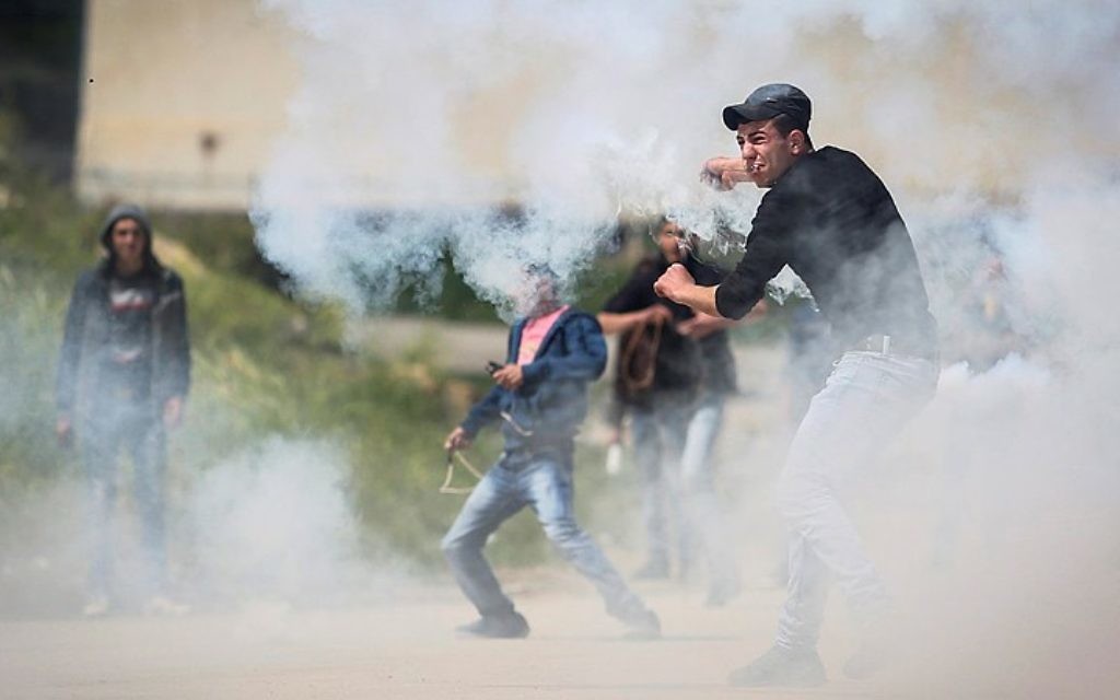 Des Palestiniens manifestent devant les forces de sécurité israéliennes pendant la "Journée de la Terre", devant la prison Ofer, gérée par les Israéliens, près de Betunia, en Cisjordanie, le 30 mars 2016. (Crédit : Flash90)