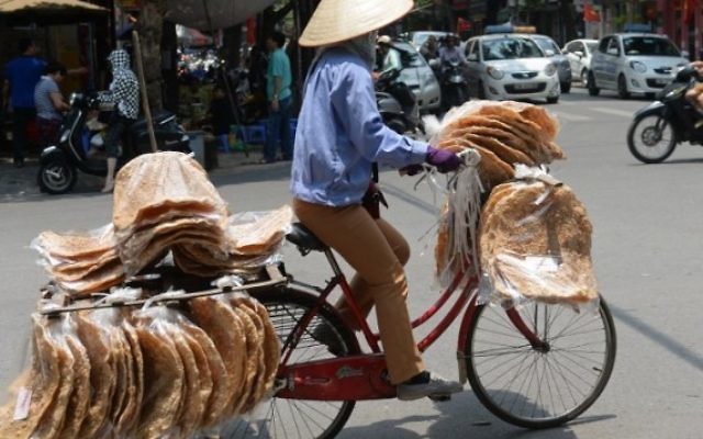 Un vendeur de rue sur son vélo dans le centre de Hanoï, au Vietnam, le 17 mai 2016. Illustration. (Crédit : AFP PHOTO/HOANG DINH NAM) Un vendeur de rue sur son vélo dans le centre de Hanoï, au Vietnam, le 17 mai 2016. Illustration. (Crédit : AFP PHOTO/HOANG DINH NAM)