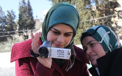 Une volontaire palestinienne de l'organisation des droits de l'homme B'Tselem apprend comment utiliser une caméra vidéo pour documenter les actions de Tsahal et des résidents des implantations de Cisjordanie, en 2014 (Crédit : B'Tselem/CC BY 4.0)