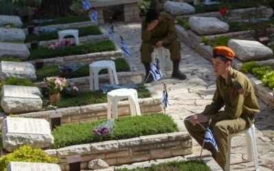 Soldats israéliens en deuil sur les tombes des soldats tombés au cimetière militaire du mont Herzl, à Jérusalem, le Jour du Souvenir, le 11 mai 2016. (Crédit : Miriam Alster/Flash90)
