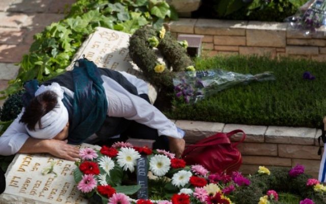 Des Israéliens en deuil sur les tombes des soldats tombés au cimetière militaire du mont Herzl, à Jérusalem, le Jour du Souvenir, le 11 mai 2016. (Crédit : Miriam Alster/Flash90)