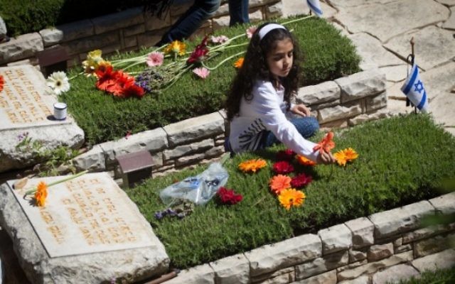 Des Israéliens en deuil sur les tombes des soldats tombés au cimetière militaire du mont Herzl, à Jérusalem, le Jour du Souvenir, le 11 mai 2016. (Crédit : Miriam Alster/Flash90)