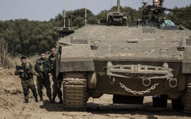 Des soldats israéliens se tiennent près d'un véhicule blindé près de la frontière entre Israël et Gaza, le mercredi 4 mai 2016. (Photo AP / Tsafrir Abayov) Des soldats israéliens se tiennent près d'un véhicule blindé près de la frontière entre Israël et Gaza, le mercredi 4 mai 2016. (Photo AP / Tsafrir Abayov)