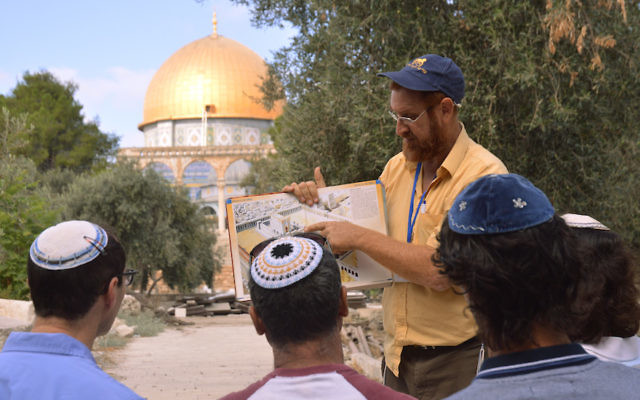Sur le mont du Temple, Yehuda Glick montre à des Juifs religieux un diagramme du Temple juif, qui se trouvait autrefois à l'emplacement du Dôme du Rocher, à Jérusalem, le 17 septembre 2013. (Crédit : Christa Case Bryant/The Christian Science Monitor via Getty Images) Sur le mont du Temple, Yehuda Glick montre à des Juifs religieux un diagramme du Temple juif, qui se trouvait autrefois à l'emplacement du Dôme du Rocher, à Jérusalem, le 17 septembre 2013. (Crédit : Christa Case Bryant/The Christian Science Monitor via Getty Images)