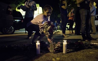 Sonia Drudge ajoute une fleur à un petit mémorial improvisé près de la boîte de nuit Pulse d'Orlando, le 12 juin 2016. (Crédit : AFP PHOTO/Brendan Smialowski)
