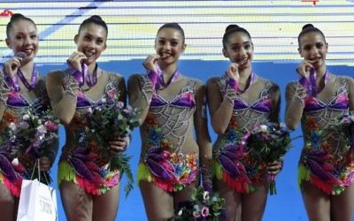 L'équipe de gymnastique rythmique israélienne célèbre sa médaille d'or sur le podium pendant les 32e championnats européens de gymnastique rythmique, qui se sont déroulés en Israël, à Holon, le 19 juin 2016. (Crédit : AFP/Thomas Coex)