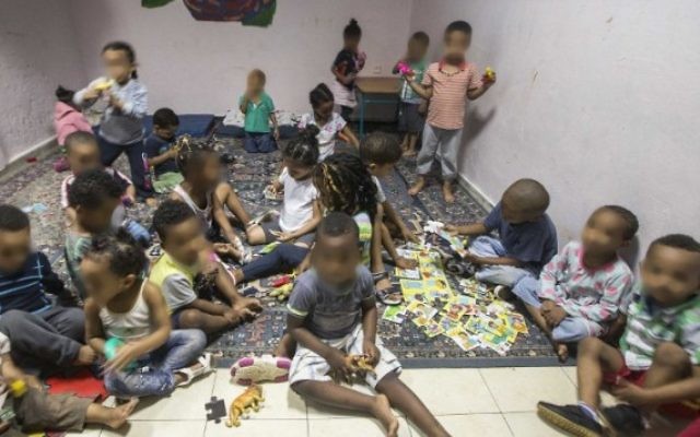 Des enfants de familles de migrants africains rassemblées dans une "crèche" dans le sud de Tel Aviv, le 28 mai 2015. Caractérisée par une saleté et une misère noire, elles ont toutes été dénoncées par des associations de défense des droits de l'Homme et les médias comme des "entrepôts à bébé". Les visages des enfants ont été floutés pour protéger leurs identités. (Crédit : AFP/Jack Guez)