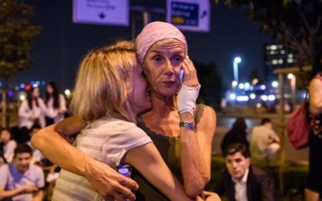 Des passagers devant l'entrée principale de l'aéroport Atatürk d'Istanbul, après un triple attentat suicide qui a tué 36 personnes et en a blessé 147, le 28 juin 2016. (Crédit : AFP/Ozan Kose)