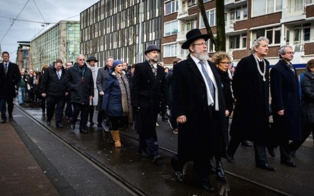 le maire d'Amsterdam Eberhard van der Laan (4e à droite) pendant une marche entre la mairie et le monument d’Auschwitz au parc Wertheimpark d'Amsterdam le 26 janvier 2014, pendant la Journée nationale du souvenir des victimes de l'Holocauste. (Crédit : AFP Photo/ANP/Remko de Waal via JTA)