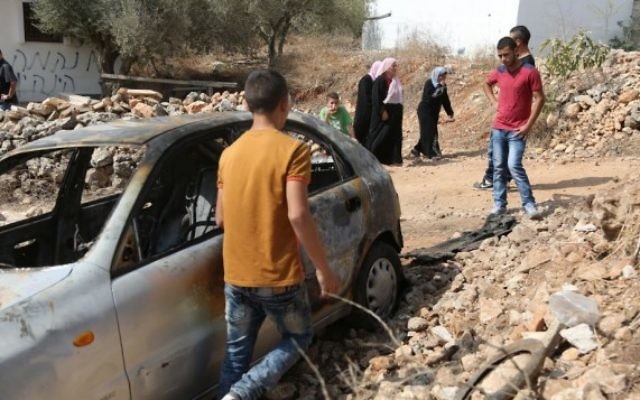 Une voiture appartenant à des Palestiniens qui, d'après des résidents locaux, aurait été brûlée par des résidents d'implantations près de la ville de Cisjordanie de Ramallah, le 2 octobre 2015 (Crédit : Flash90) Une voiture appartenant à des Palestiniens qui, d'après des résidents locaux, aurait été brûlée par des résidents d'implantations près de la ville de Cisjordanie de Ramallah, le 2 octobre 2015 (Crédit : Flash90)