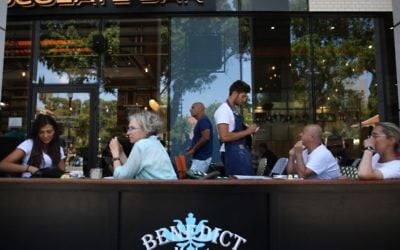 Des Israéliens mangent au restaurant Benedict du centre commercial Sarona, dans le centre de Tel Aviv, quelques heures après une fusillade terroriste qui y a tué quatre personnes, le 9 juin 2016. (Crédit : Miriam Alster/Flash90)