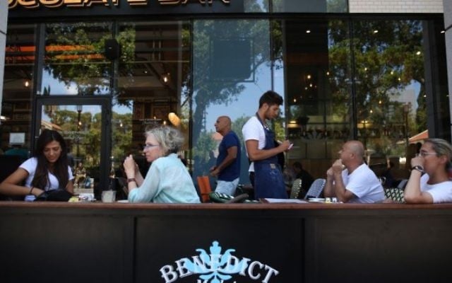 Des Israéliens mangent au restaurant Benedict du centre commercial Sarona, dans le centre de Tel Aviv, quelques heures après une fusillade terroriste qui y a tué quatre personnes, le 9 juin 2016. (Crédit : Miriam Alster/Flash90)