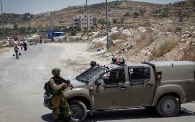 Soldats israéliens à un checkpoint à l'entrée du village palestinien de Yatta, en Cisjordanie, le 9 juin 2016. (Crédit : Wisam Hashlamoun/Flash90)