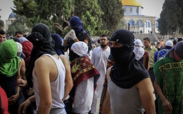Des Palestiniens masqués avec des pierres pendant des affrontements avec la police sur le mont du Temple, dans la Vieille Ville de Jérusalem, le 28 juin 2016. (Crédit : Muammar Awad/Flash90)