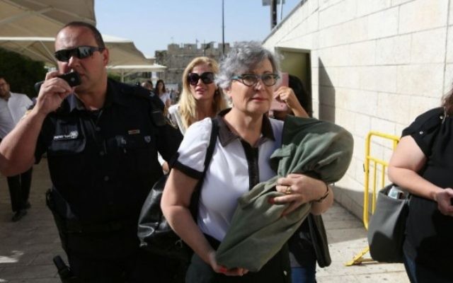 Leslie Sachs, directrice des Femmes du Mur, porte un rouleau de Torah pendant qu'elle est escortée par des policiers à l'écart du mur Occidental, à Jérusalem, le 7 juin 2016. (Crédit : Michal Fattal) Leslie Sachs, directrice des Femmes du Mur, porte un rouleau de Torah pendant qu'elle est escortée par des policiers à l'écart du mur Occidental, à Jérusalem, le 7 juin 2016. (Crédit : Michal Fattal)