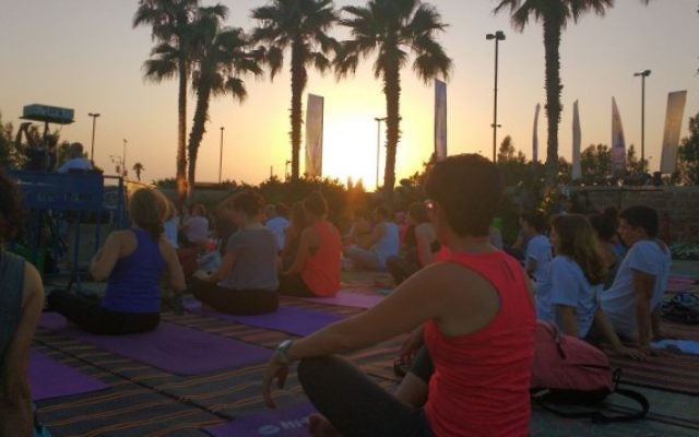 Des centaines de personnes assistent à la master class de la deuxième Journée internationale du Yoga, à Tel Aviv, le 21 juin 2016. (Crédit : Melanie Lidman) Des centaines de personnes assistent à la master class de la deuxième Journée internationale du Yoga, à Tel Aviv, le 21 juin 2016. (Crédit : Melanie Lidman)