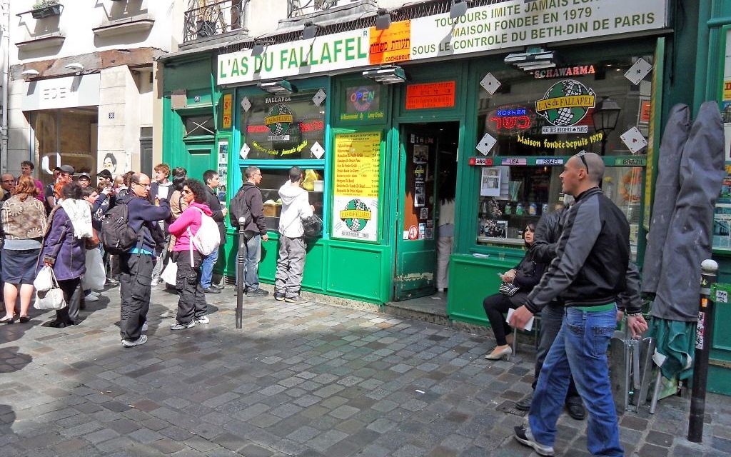 Yomi Peretz, à droite, s'approche de la queue de clients attendant de pouvoir commander à l'As du Fallafel, dans le quartier juif historique de Paris, en avril 2012. (Crédit : WikiCommons)