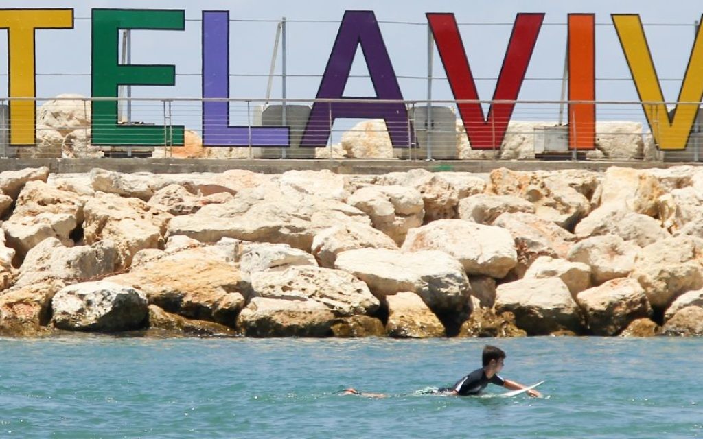 Un surfer sur la plage de Tel Aviv, Hilton Beach, considérée comme un lieu de rencontre pour la communauté LGBT, durant la semaine de la Gay Pride de 2015 (Crédit : Matthew Hechter/Flash 90) Un surfer sur la plage de Tel Aviv, Hilton Beach, considérée comme un lieu de rencontre pour la communauté LGBT, durant la semaine de la Gay Pride de 2015 (Crédit : Matthew Hechter/Flash 90)