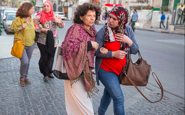 Annie Kurland et une collègue enseignante au marché Mahane Yehuda de Jérusalem en 2016, dans le cadre du projet de coexistence Salle des profs 2016, qui comprend une exposition de photos visible au YMCA de Jérusalem. (Crédit : Dana Talel) Annie Kurland et une collègue enseignante au marché Mahane Yehuda de Jérusalem en 2016, dans le cadre du projet de coexistence Salle des profs 2016, qui comprend une exposition de photos visible au YMCA de Jérusalem. (Crédit : Dana Talel)