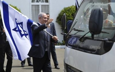 Le Premier ministre Benjamin Netanyahu avec un drapeau israélien après une conférence de presse commune avec le président du Kenya, à Nairobi, le 5 juillet 2016. (Crédit : AFP/Simon Maina) Le Premier ministre Benjamin Netanyahu avec un drapeau israélien après une conférence de presse commune avec le président du Kenya, à Nairobi, le 5 juillet 2016. (Crédit : AFP/Simon Maina)
