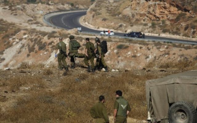 Des soldats israéliens évacuent un soldat blessé après l'explosion d'une grenade près du village de Majdal Shams, sur le plateau du Golan, le 17 juillet 2016. (Crédit : AFP/Jalaa Marey)