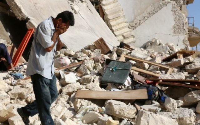 Un Syrien réagit alors que les secouristes recherchent des victimes sous les décombres d'un bâtiment effondré suite à une frappe aérienne sur le quartier rebelle de Sakhur dans la ville du nord, Alep, le 19 juillet, 2016 (Crédit : AFP / Thaer Mohammed) Un Syrien réagit alors que les secouristes recherchent des victimes sous les décombres d'un bâtiment effondré suite à une frappe aérienne sur le quartier rebelle de Sakhur dans la ville du nord, Alep, le 19 juillet, 2016 (Crédit : AFP / Thaer Mohammed)