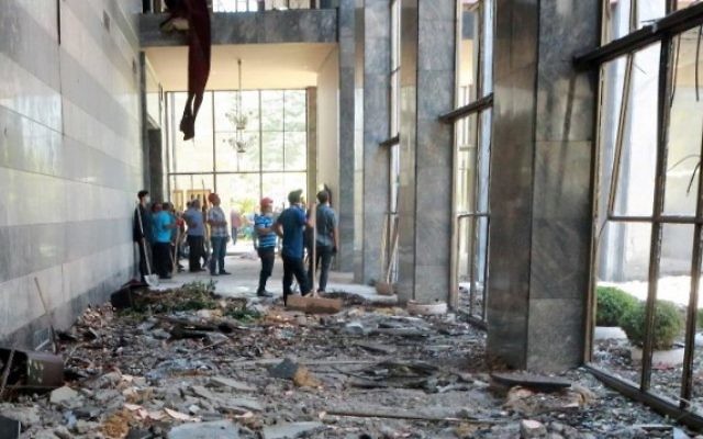 Des ouvriers inspectent et nettoient les débris après les bombardements de la Grande Assemblée nationale de Turquie par des avions participant à la tentative de coup d'Etat militaire, à Ankara, le 16 juillet 2016. (Crédit : AFP/Adem Altan) Des ouvriers inspectent et nettoient les débris après les bombardements de la Grande Assemblée nationale de Turquie par des avions participant à la tentative de coup d'Etat militaire, à Ankara, le 16 juillet 2016. (Crédit : AFP/Adem Altan)