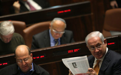 Le Premier Benjamin Netanyahu lit le journal à la Knesset, le 6 janvier 2010. (Crédit : Kobi Gideon/Flash90)