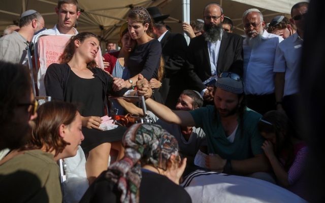 Tehila Mark, blessée dans une attaque terroriste dans laquelle son père, Miki Mark, est décédé, assiste à ses funérailles aux côtés d'autres membres de la famille, au cimetière Har Hamenuhot, à Jérusalem, dimanche 3 juin 2016 (Miriam Alster/Flash90