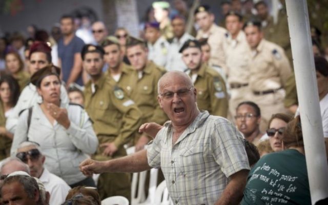 Yoram Tal, dont le fils de 22 ans, Omri, a été tué au combat pendant la guerre de Gaza en 2014, interrompt le Premier ministre Benjamin Netanyahu pendant une cérémonie marquant les deux ans du conflit au cimetière militaire du mont Herzl, à Jérusalem, le 26 juillet 2016. (Crédit : Miriam Alster/Flash90)