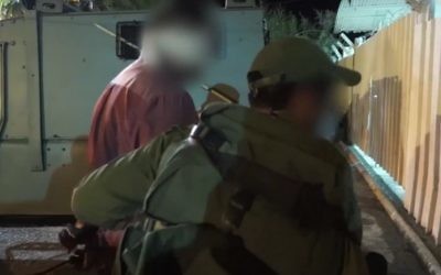 Les troupes israéliennes arrêtent un homme pendant un raid en Cisjordanie pour arrêter une cellule du Hamas responsable de la mort du rabbin Miki Mark, le 27 juillet 2016. (Crédit : capture d'écran YouTube)