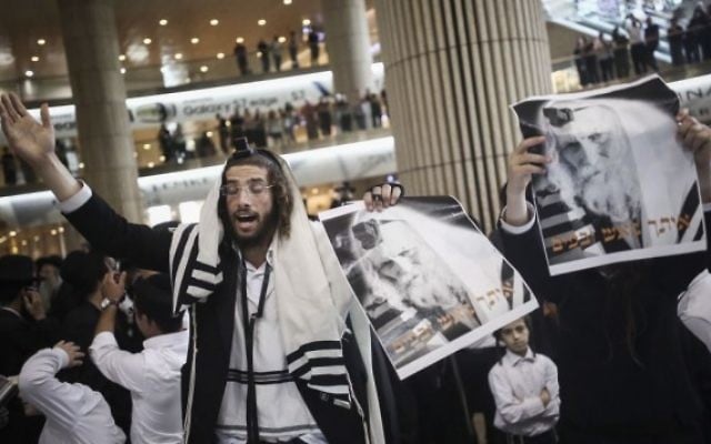 Des Juifs ultra-orthodoxes se rassemblent pour prier lors d'une manifestation de soutien au rabbin Eliezer Berland avant son arrivée à l'aéroport Ben Gourion à Tel Aviv, le 19 juillet 2016. (Crédit photo : Yonatan Sindel/Flash90) Des Juifs ultra-orthodoxes se rassemblent pour prier lors d'une manifestation de soutien au rabbin Eliezer Berland avant son arrivée à l'aéroport Ben Gourion à Tel Aviv, le 19 juillet 2016. (Crédit photo : Yonatan Sindel/Flash90)