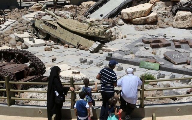 Des visiteurs regardent des chars laissés au Liban par l'armée israéliennes au "Musée-monument touristique de la Résistance' créé par le Hezbollah  à Mlita  dans le sud du Liban, le 12 juillet 2016 (Crédit : MAHMOUD ZAYYAT / AFP )