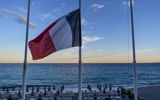Drapeau français en berne devant une plage vide de la Promenade des Anglais à Nice, au lendemain d'un attentat qui a fait 84 morts, le 15 juillet 2016. (Crédit : David Ramos/Getty Images via JTA) Drapeau français en berne devant une plage vide de la Promenade des Anglais à Nice, au lendemain d'un attentat qui a fait 84 morts, le 15 juillet 2016. (Crédit : David Ramos/Getty Images via JTA)