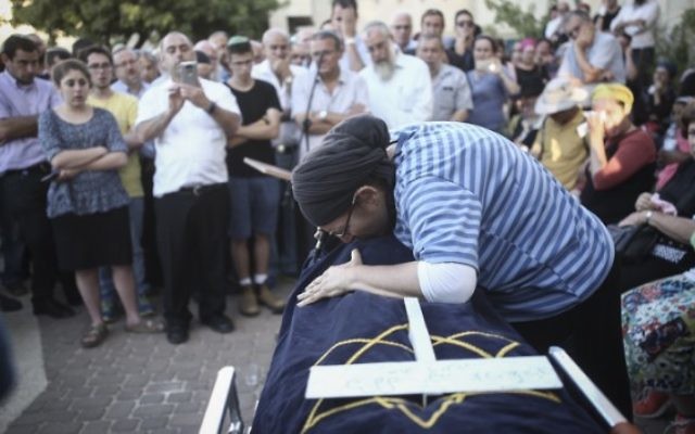Rina Ariel pleure sur la dépouille de sa fille de 13 ans, Hallel Yaffa, qui a été poignardée à mort par un terroriste palestinien dans sa chambre, pendant son éloge funèbre, dans l'implantation de Kiryat Arba, le 30 juin 2016. (Crédit : Yonatan Sindel/Flash90) Rina Ariel pleure sur la dépouille de sa fille de 13 ans, Hallel Yaffa, qui a été poignardée à mort par un terroriste palestinien dans sa chambre, pendant son éloge funèbre, dans l'implantation de Kiryat Arba, le 30 juin 2016. (Crédit : Yonatan Sindel/Flash90)