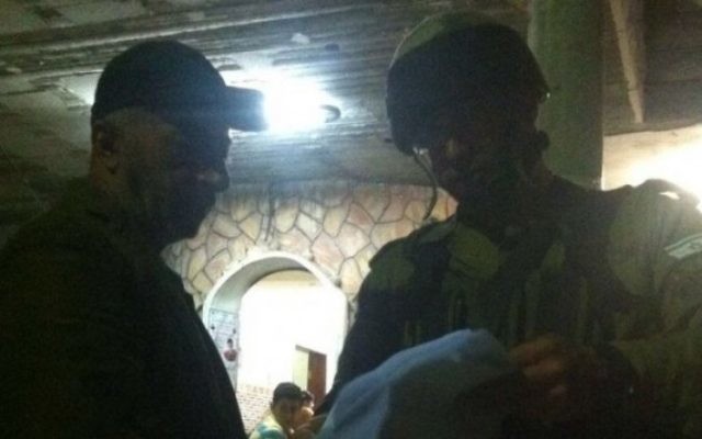 Des soldats israéliens remettent un ordre de démolition à la résidence de Muhammad Tarayrah, le terroriste palestinien de 17 ans qui avait assassiné dans son lit à Kiryat Arba Hallel Yaffa Ariel, 13 ans, à Bani Naim, le 5 juillet 2016. (Crédit : porte-parole de l'armée israélienne)