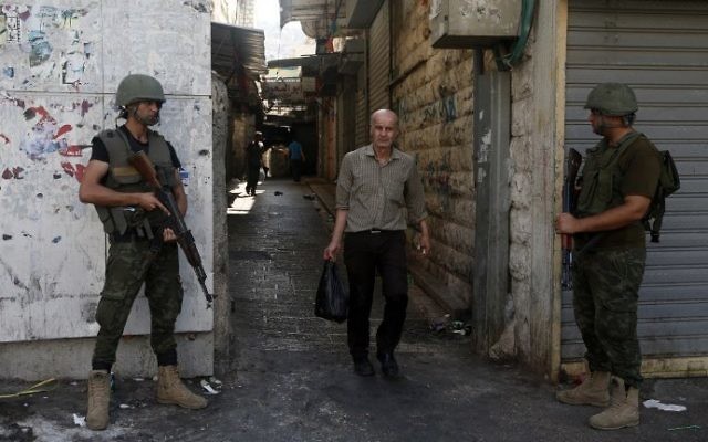 Les membres des forces de sécurité palestiniennes montent la garde alors qu'ils patrouillent la ville de Naplouse en Cisjordanie le 23 août, 2016. (Crédit : AFP/ JAAFAR ASHTIYEH)