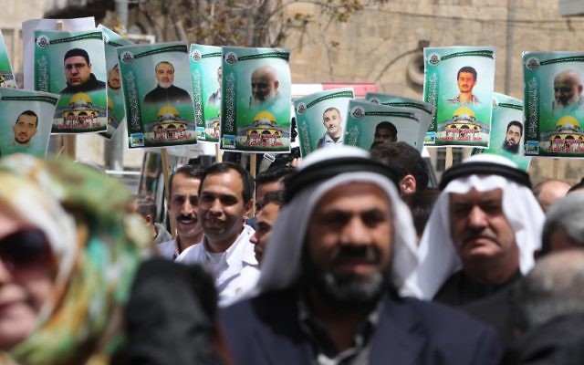 Portraits des membres du groupe terroriste Hamas qui sont emprisonnés dans les prisons israéliennes, lors d'une manifestation de soutien dans la ville de Hébron en Cisjordanie, le 15 avril 2015 (Crédit : AFP PHOTO / HAZEM BADE)
