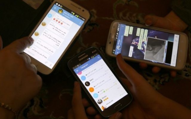 Des Iraniens utilisent l'application Telegram sur leurs téléphones, le 1er décembre 2015. (Crédit : AFP/Atta Kenare) Des Iraniens utilisent l'application Telegram sur leurs téléphones, le 1er décembre 2015. (Crédit : AFP/Atta Kenare)