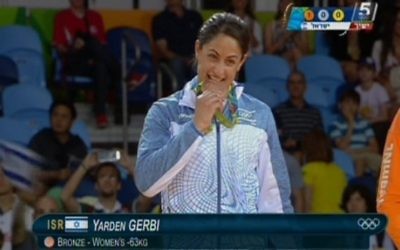 La judokate israélienne Yarden Gerbi mord sa médaille de bronze, obtenue dans le tournoi de judo féminin des -63kg aux Jeux olympiques de Rio, le 9 août 2016. (Crédit : capture d’écran Chaîne 55)