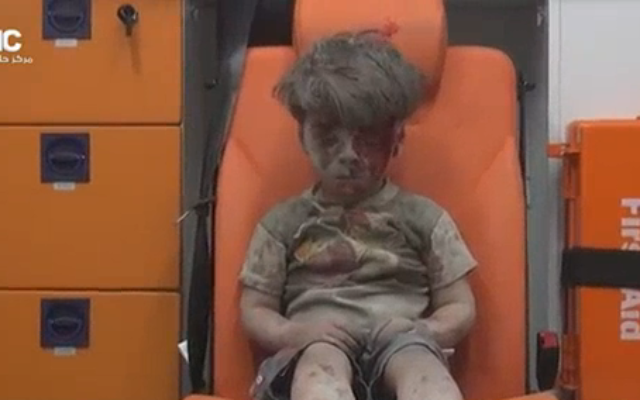 Capture d’écran de la vidéo du Aleppo Media Center du petit Omrane, survivant d'une frappe aérienne en Syrie Capture d’écran de la vidéo du Aleppo Media Center du petit Omrane, survivant d'une frappe aérienne en Syrie